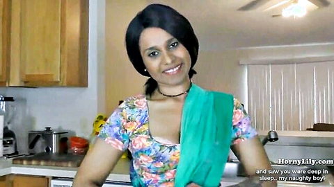 Sexy Indian stepmom in floral saree blouse smiling teasingly in kitchen with cleavage