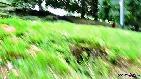 Blurry motion-blurred green grass hill with trees and pole in outdoor landscape