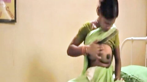 Indian babe in green saree lifts blouse exposing perky tit and dark nipple on bed