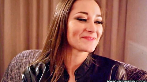 Dani Daniels smiling seductively in black leather jacket, inviting gaze