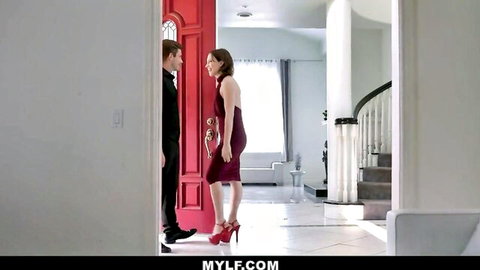Elegant brunette MILF in tight red dress flirts with suited hunk at luxurious red door entrance