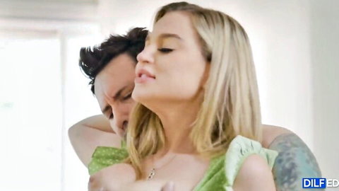 Blonde babe in green dress passionately kissed by tattooed DILF daddy from behind