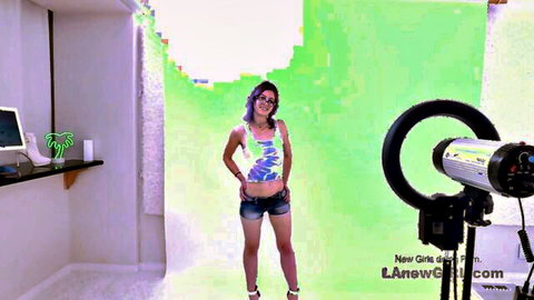 Gorgeous Latina newbie posing confidently in colorful crop top and shorts for audition