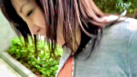Japanese housewife smiling seductively outdoors in gray top