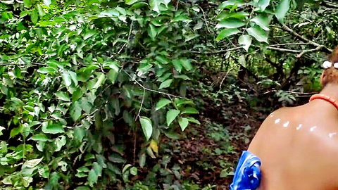 Ebony beauty with beaded hair and red necklace, bare back in lush African jungle