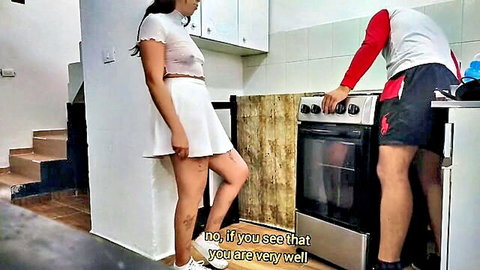 Curvy Latina in sheer white crop top and tiny skirt standing seductively in kitchen with boyfriend