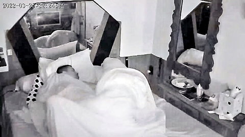 Blurry woman lying covered by white sheets in mirrored bedroom