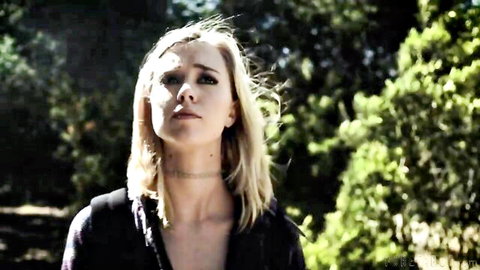 Blonde teen with small natural tits showing cleavage in low-cut black top outdoors