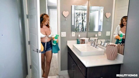 Sexy redhead in crop top and shorts cleaning, showing big cleavage