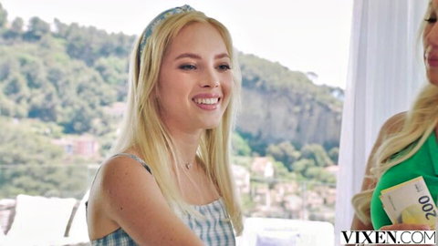 Bella Spark smiles with blonde temptress holding cash in steamy outdoor setup