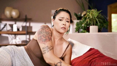Tattooed brunette Dana Vespoli lounging emotionally on bed in tank top