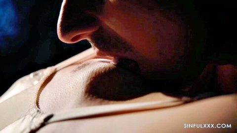 Man passionately kissing woman's cleavage in sexy white lace bra