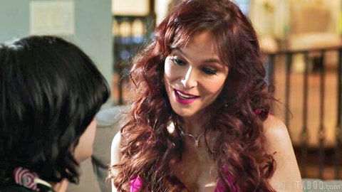 Redhead MILF in pink top smiles seductively at young man showing deep cleavage