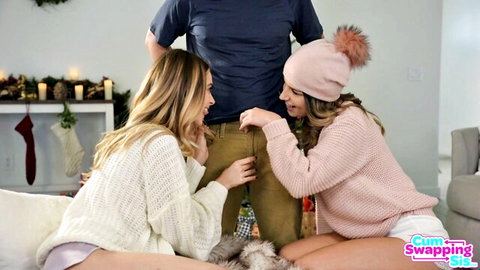 Two blonde girls in Christmas sweaters pull down guy's khaki pants exposing his big bulging cock