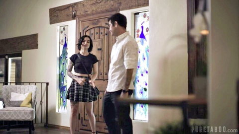 Young skinny brunette in short plaid skirt stands close flirting with handsome man in white shirt