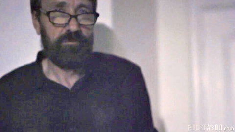 Bearded stepdad in dark shirt stares intensely in Riley Star's taboo deepthroat video