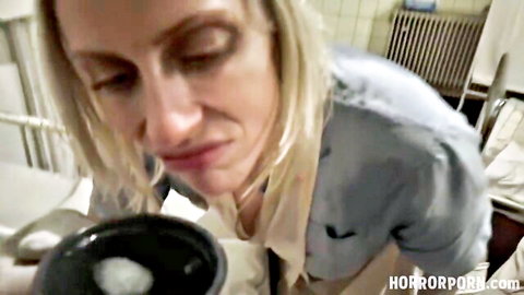 Blonde woman in open blue shirt eyeing bowl of white cum in taboo fetish scene