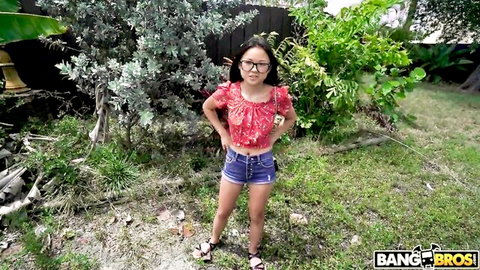 Lulu Chu posing in red floral top and denim shorts outdoors