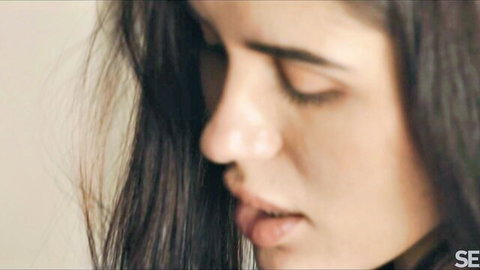 Jadilica's sensual profile close-up with long dark hair, teasing gaze