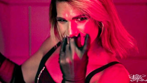 Blonde bombshell in black gloves hand-gagging her open mouth with seductive intense stare