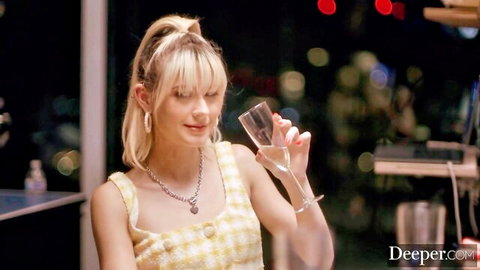 Blonde woman in yellow gingham top holding champagne glass seductively