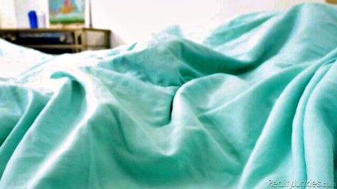 Close-up of rumpled light blue bedsheets on messy bedroom bed