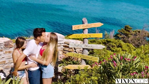 Naomi Swann and Talia Mint embracing Alberto Blanco on sunny beach