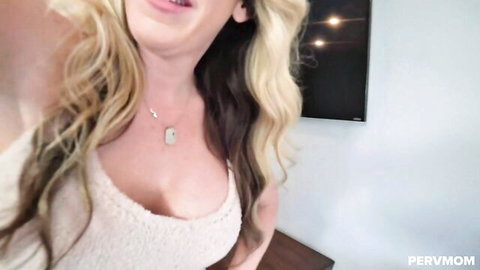 Blonde MILF teases deep cleavage and big tits in fuzzy sweater selfie