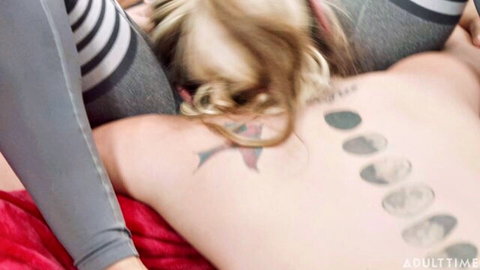 Blonde tattooed woman in gray leggings during intimate midday ritual