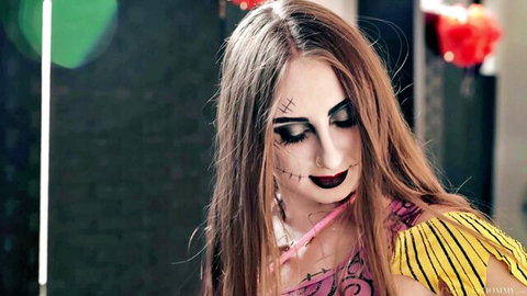 Seductive brunette in Halloween ragdoll costume with black stitch makeup and sultry gaze