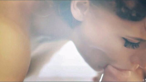 Curly-haired brunette beauty sucking thick cock head with glossy lips in steamy closeup blowjob