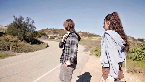Reagan Foxx in hoodie and shorts walks with Tyler Cruise outdoors