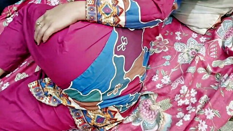 Curvy Desi stepdaughter in pink patterned salwar kameez lying seductively on bed
