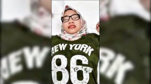 Malay beauty in tudung with glasses, lying seductively