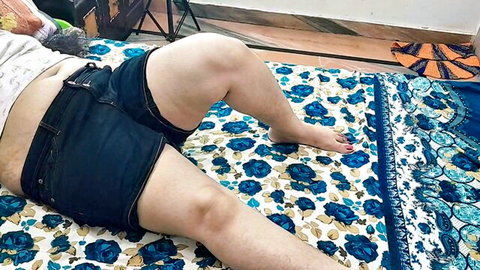 Seductive Indian woman in shorts, thick thighs spread on bed