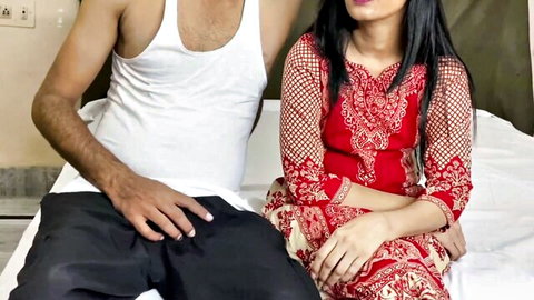 Indian Desi couple posing intimately, woman in red embroidered dress