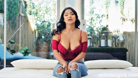 Numi Zarah seductive in red low-cut top and ripped jeans casting tease