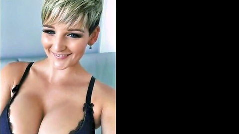 Hannah Brooks smiling in black lace bra, showcasing large fake tits selfie