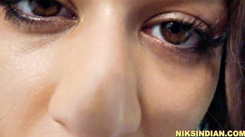 Seductive close-up of Indian woman's brown eyes during intense honeymoon sex