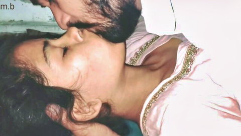 Indian couple in passionate neck kiss, woman in pink embroidered top