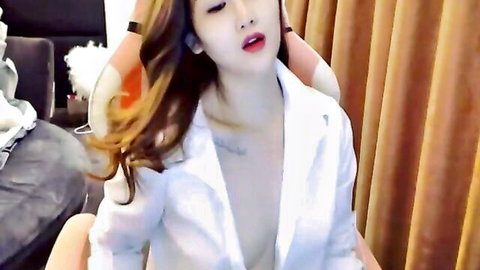 Seductive Korean beauty in open white blazer revealing deep cleavage