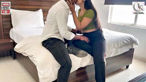 Indian woman in green crop top kissing man intimately on bed