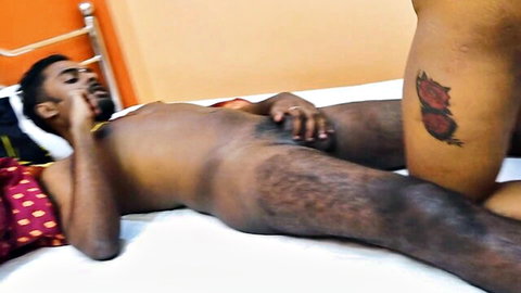 Nude Desi man on bed, hand on cock, tattooed leg in intimate Indian scene
