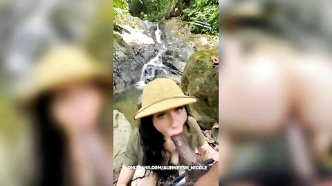Babe in safari hat sucks thick BBC outdoors by jungle waterfall