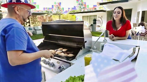 Bald man in Uncle Sam hat grills burgers while smiling brunette in red top watches from poolside