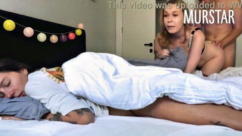 Muscular naked guy fucks tattooed brunette doggy style from behind while blonde babe watches in amateur threesome