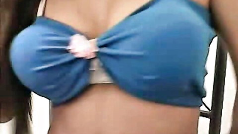 Busty Asian tranny in blue bra with pink bow, teasing cleavage