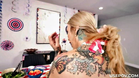 Tattooed blonde MILF with massive back tattoo and patriotic ponytail bow in festive room