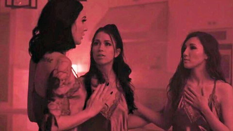 Tattooed brunette babe touches two sexy young brunettes intimately in red-lit taboo tease