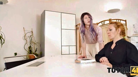 Purple-haired student leans over redhead MILF tutor at desk in kinky lesson scene
